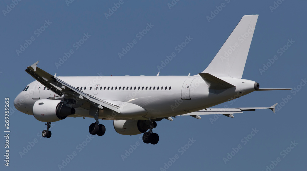 Big modern white aircraft on the blue sky background