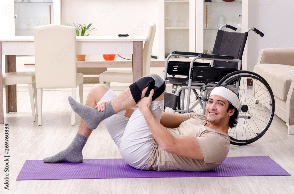 Injured young man doing exercises at home Injured young man doing exercises at home