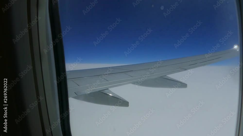 Look out the window of the porthole of the aircraft. The girl sees in the porthole wing of the aircraft. Traveling by air. Fly above the clouds. Look out the window of the porthole of the aircraft. The girl sees in the porthole wing of the aircraft. Traveling by air. Fly above the clouds.