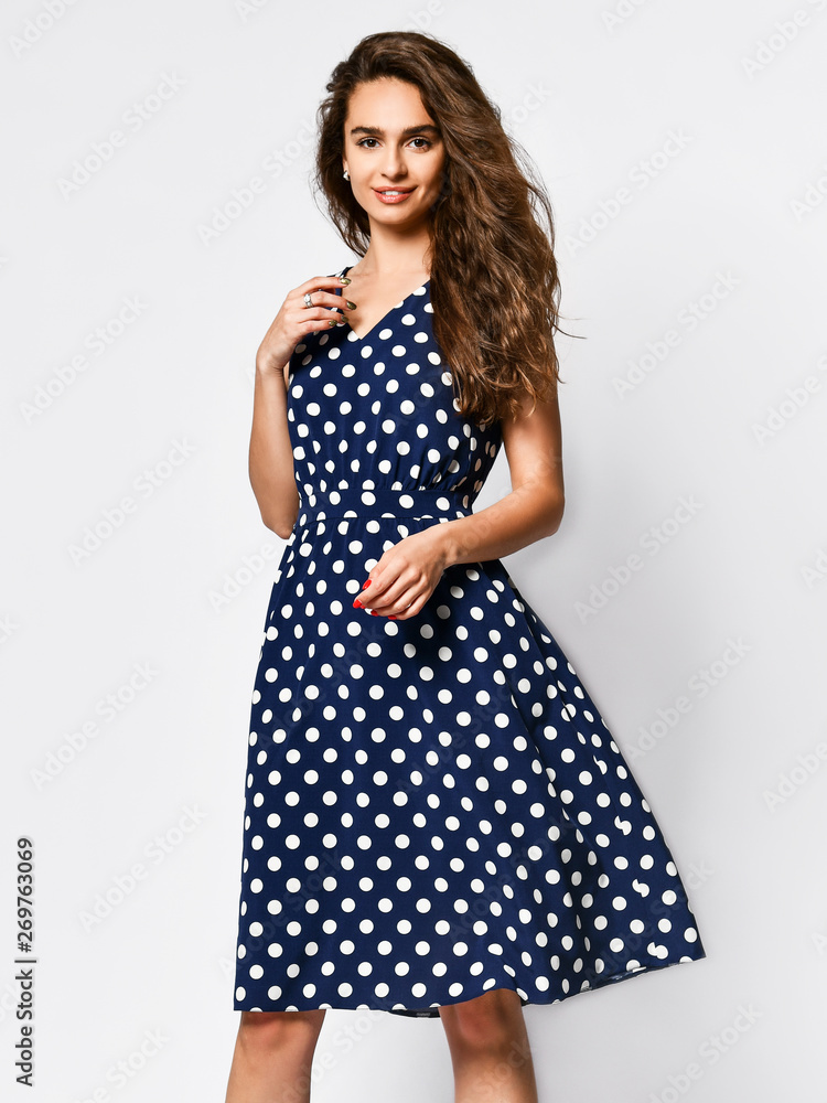 Woman in polka dot Dress in Fashion Store - Portrait of girl in a clothes shop in a midi summer dress Woman in polka dot Dress in Fashion Store - Portrait of girl in a clothes shop in a midi summer dress
