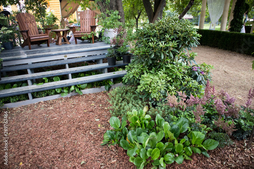 the wooden chairs on a wooden podium in the garden among the plants