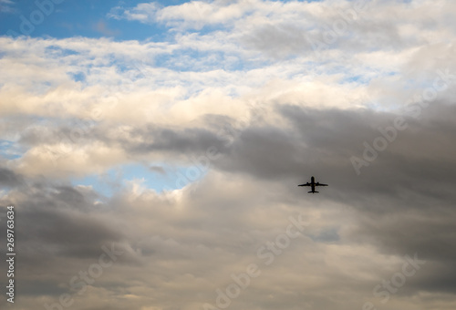 Passenger jet airplane on the background of the cloudy sky. Spring evening  overcast. Airplanes take off from the airport nearby.