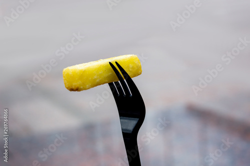 Fast food fries on black fork isolated