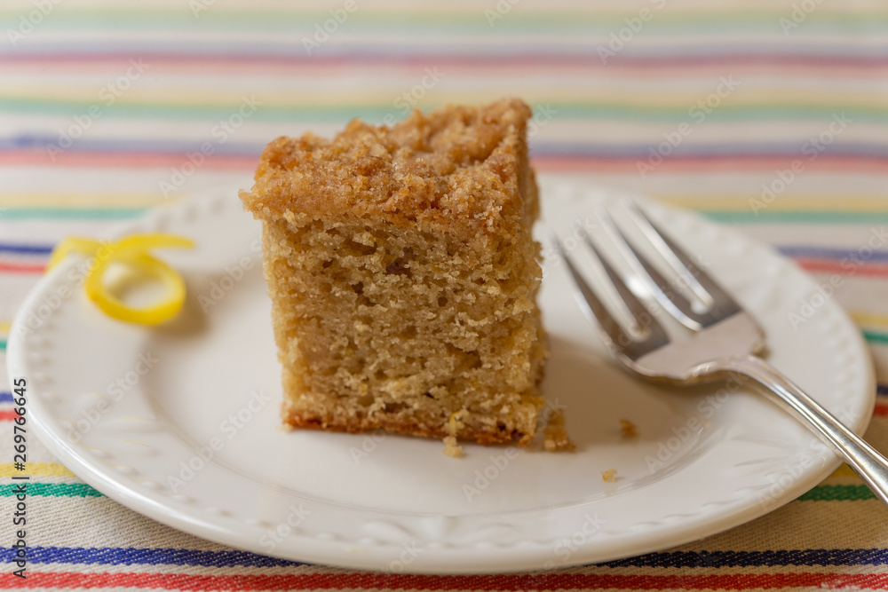 Lemon crumb cake on white plate with striped background Lemon crumb cake on white plate with striped background