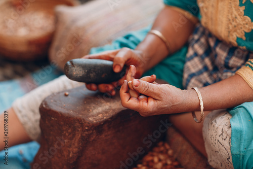 Tableau sur toile Woman making argan oil by hand craft
