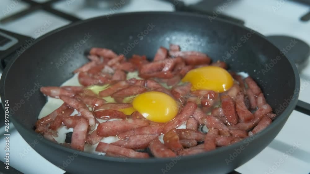 Cook breakfast. Sausage with eggs in a pan. Hot breakfast in a pan. Cook breakfast. Sausage with eggs in a pan. Hot breakfast in a pan.