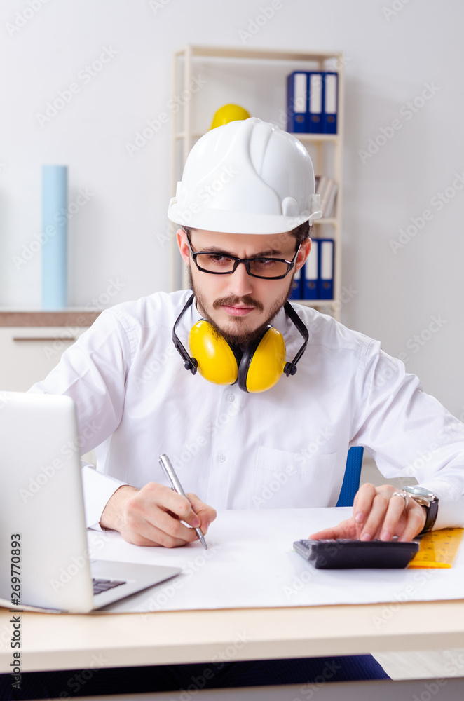 Young male architect working in the office Young male architect working in the office
