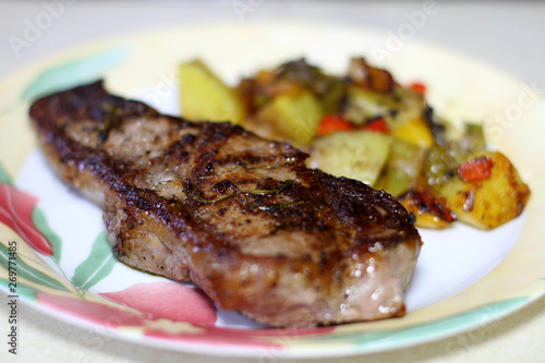 NY strip steak with potatoes on a plate.