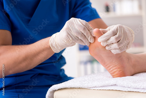 Canvas-taulu Podiatrist treating feet during procedure