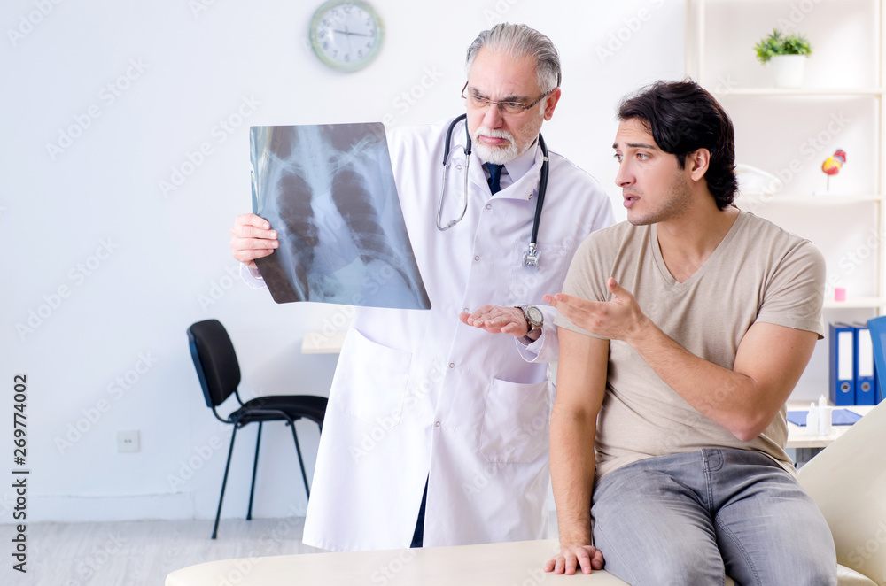 Obraz premium Young man visiting old male doctor radiologist