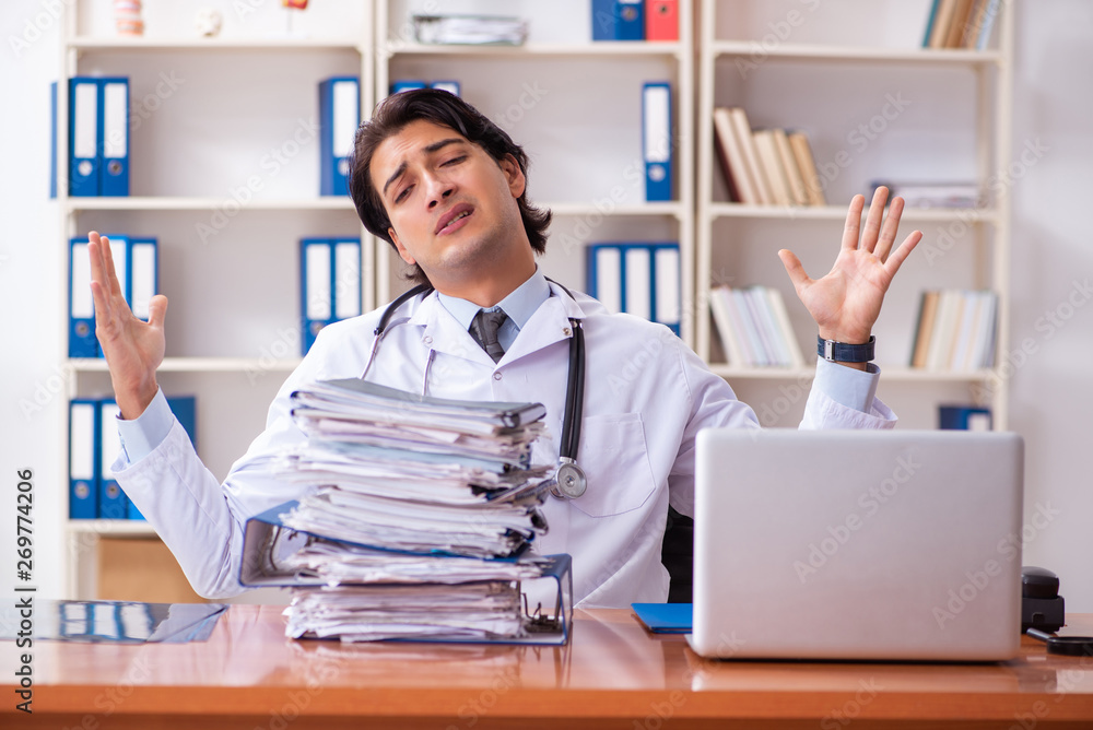 Young handsome doctor working in the clinic 