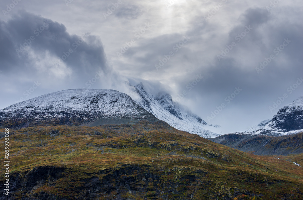 Landscape of snowy mountains and cloudy sky in Norway in summer