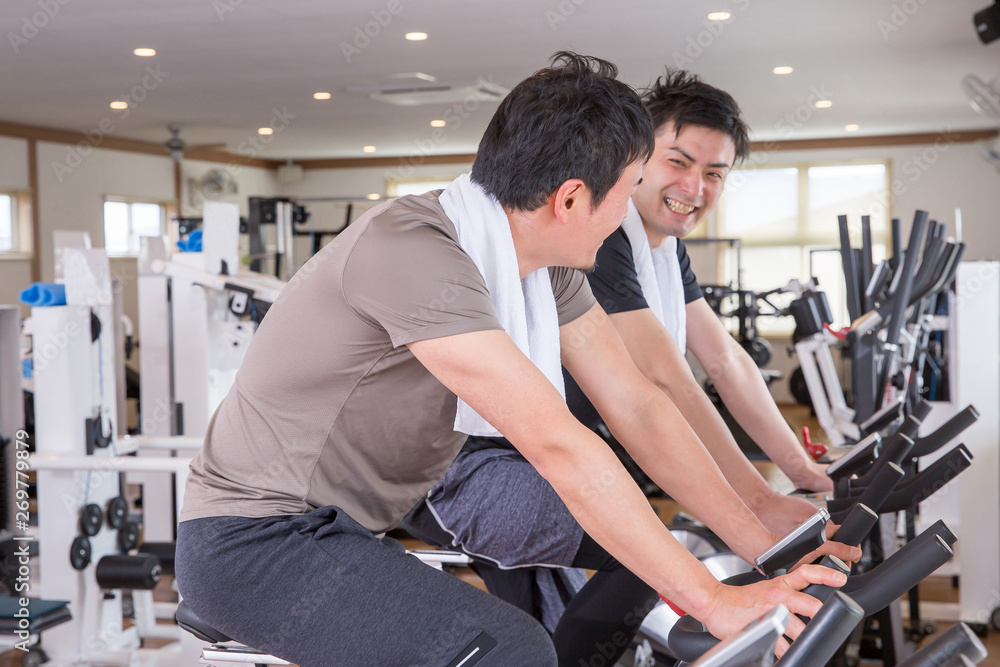 スポーツジムで自転車をこぐ男性 スポーツジムで自転車をこぐ男性