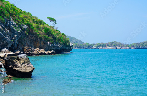 At seaside in summer ,waves on stone beach shore . blue sea blue sky background .Travel, Vacation and Holiday concept . Tropical beach . © oatautta