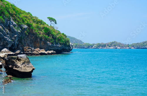 At seaside in summer ,waves on stone beach shore . blue sea blue sky background .Travel, Vacation and Holiday concept . Tropical beach .