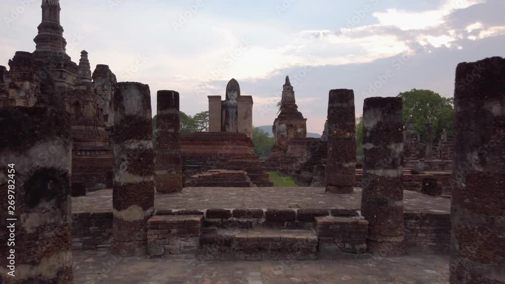 Push through views of large stone column ruins site at Wat Mahathat temple during sunset, Sukhothai, Thailand Push through views of large stone column ruins site at Wat Mahathat temple during sunset, Sukhothai, Thailand