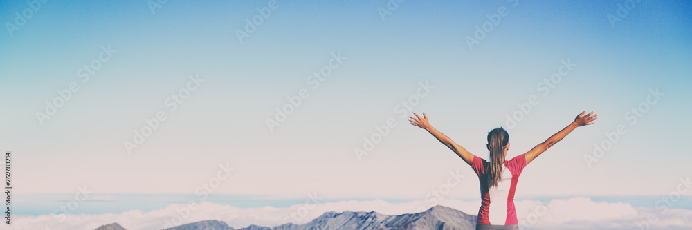 Winning success banner woman reaching summit goal with arms up in the air panorama. Blue sky background. Girl living her life to the fullest fulfilling her dreams - bucket list concept. Winning success banner woman reaching summit goal with arms up in the air panorama. Blue sky background. Girl living her life to the fullest fulfilling her dreams - bucket list concept.
