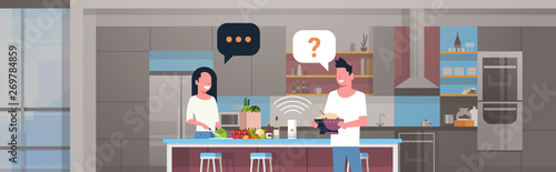 couple using smart speaker man woman preparing food asking recipe voice recognition concept modern kitchen interior flat horizontal portrait