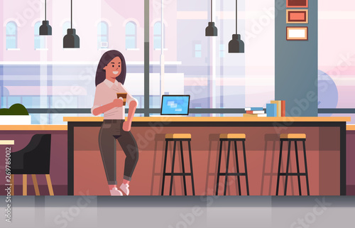 businesswoman sitting on chair at bar counter with laptop coffee break concept business woman drinking cappuccino modern cafe interior flat full length horizontal