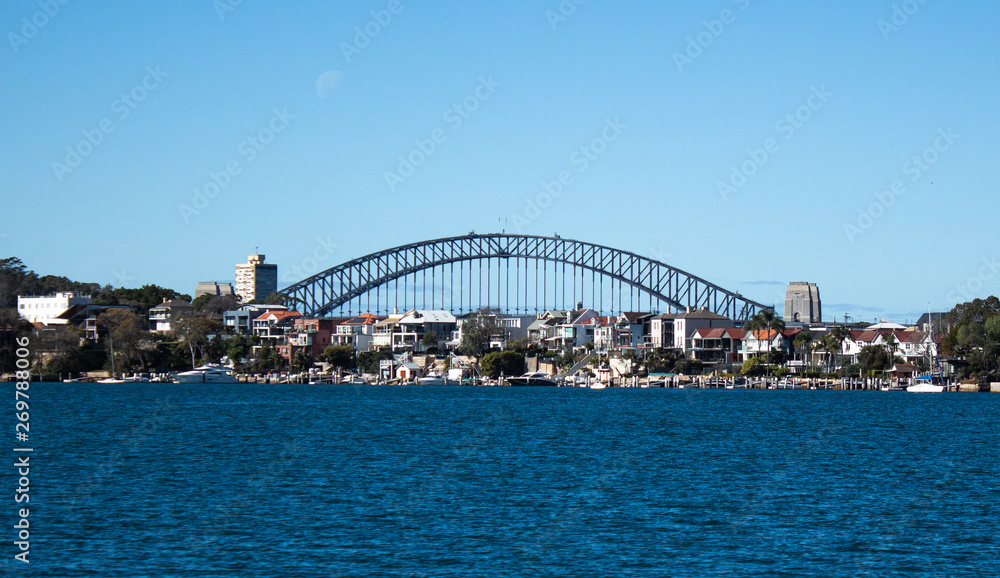 City Harbourside houses at Robinsons Point Birchgrove Sydney Australia with Harbour bridge in background against blue sky