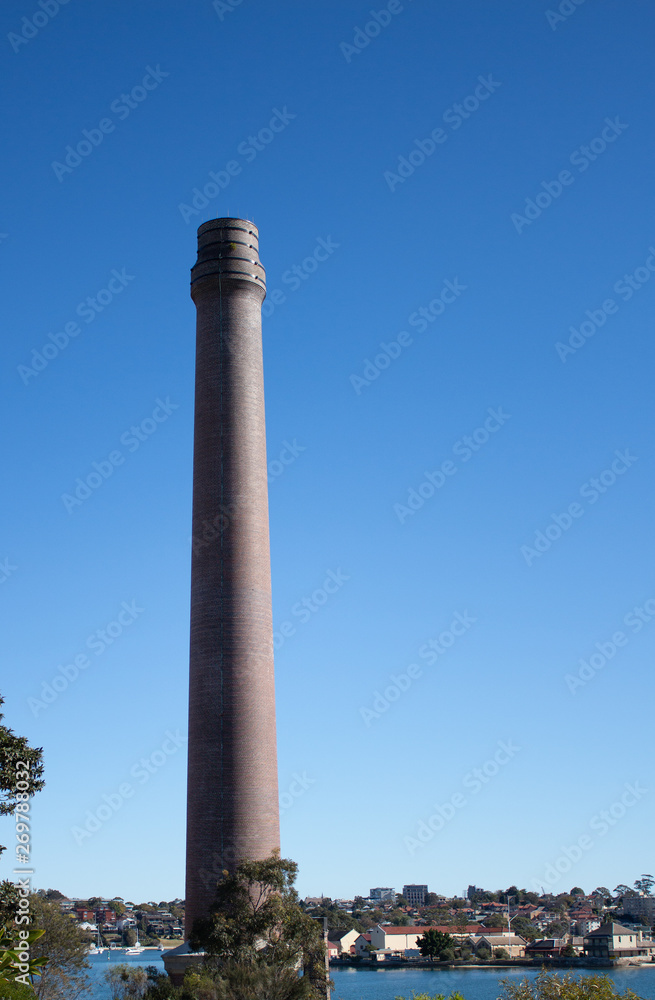 Factory brick smoke stack against blue sky set on Cockatoo Island Sydney Harbour Australia