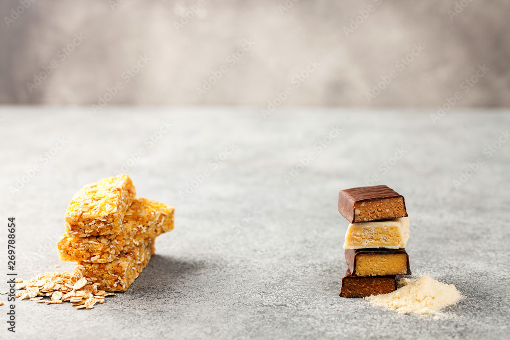 Different Energy protein bars and oatmeal bars on grey background. Set of energy, sport, breakfast and protein bars Different Energy protein bars and oatmeal bars on grey background. Set of energy, sport, breakfast and protein bars