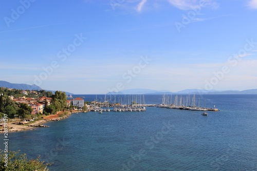 Harbor of Palairos town in Aitolakarnania in Greece at summer. Background view sailing boats moored and tied at the small marina