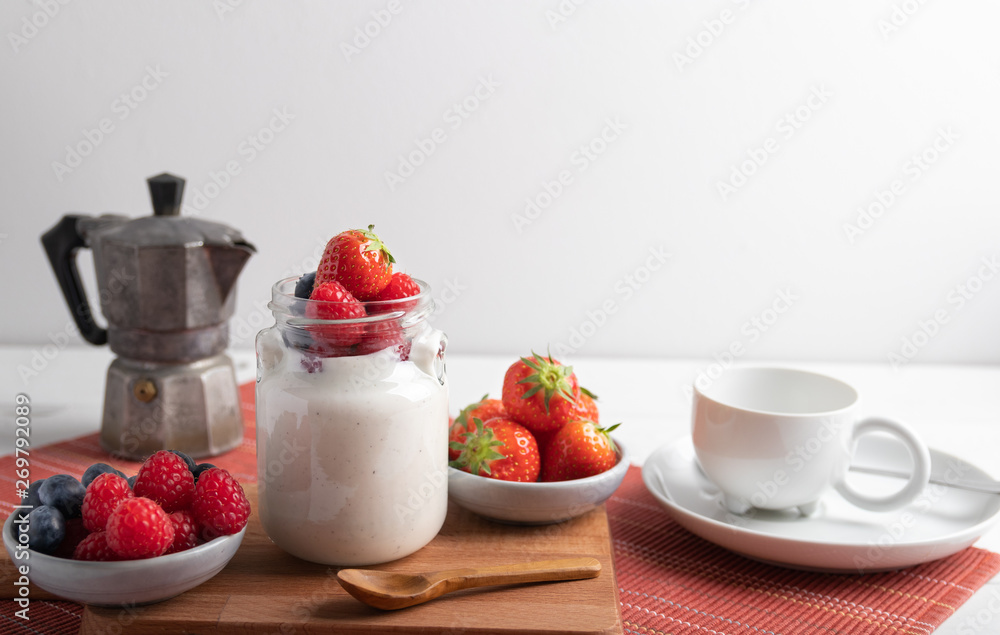 A serving of yogurt with fresh fruit on a breakfast table A serving of yogurt with fresh fruit on a breakfast table