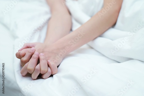 Men shake hands with women having sex on the bed with pleasure