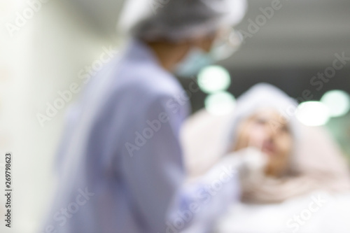 Blurred the surgeon and his assistant performing cosmetic surgery,injection collagen healthy for beauty on face, procedure rejuvenation for treatment skin