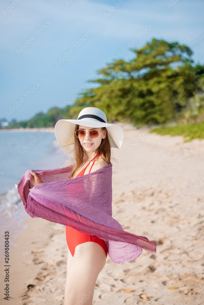 Portrait of beautiful woman in red swimsuit relaxing on the beach Portrait of beautiful woman in red swimsuit relaxing on the beach