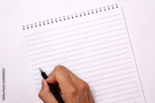 Empty notebook with a male hand and a black pen with a place under the text
