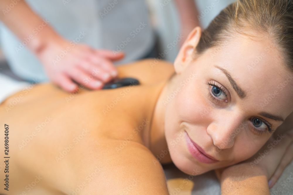 beautiful and healthy woman during a back stone therapy