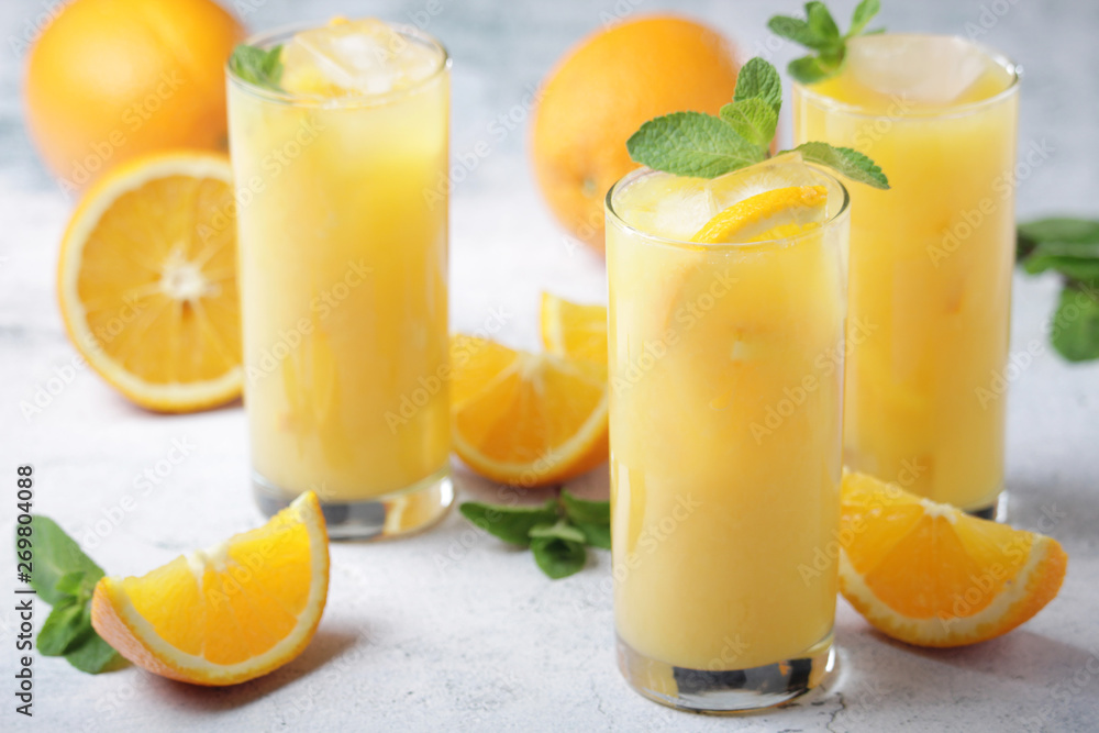 Glasses full of orange juice with ice Glasses full of orange juice with ice