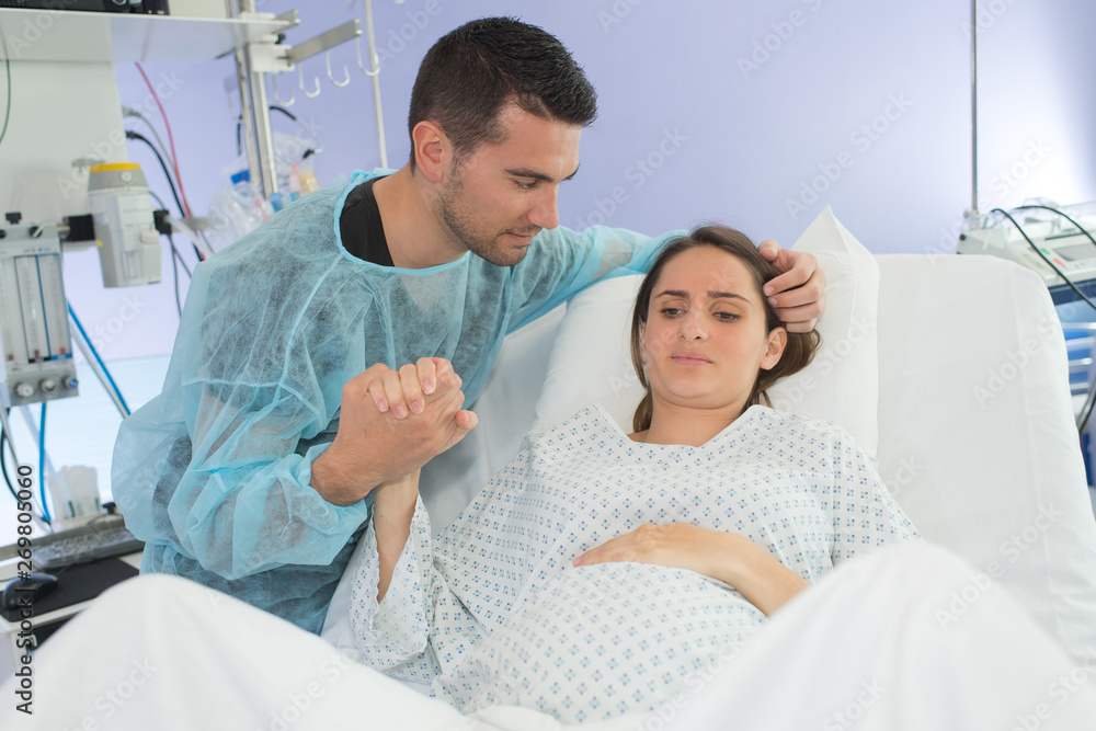 Woman in labor, partner holding her hand Woman in labor, partner holding her hand