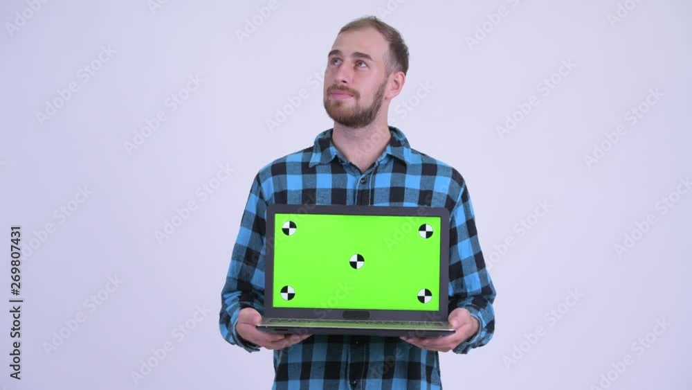 Happy bearded hipster man thinking while showing laptop Happy bearded hipster man thinking while showing laptop