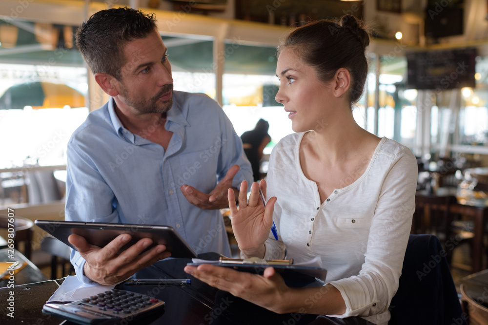 two worried executives reading documents in a bar two worried executives reading documents in a bar