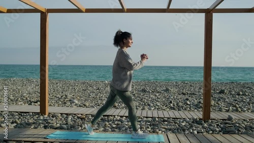 Girl exrcising outdoor on sea shore. photo