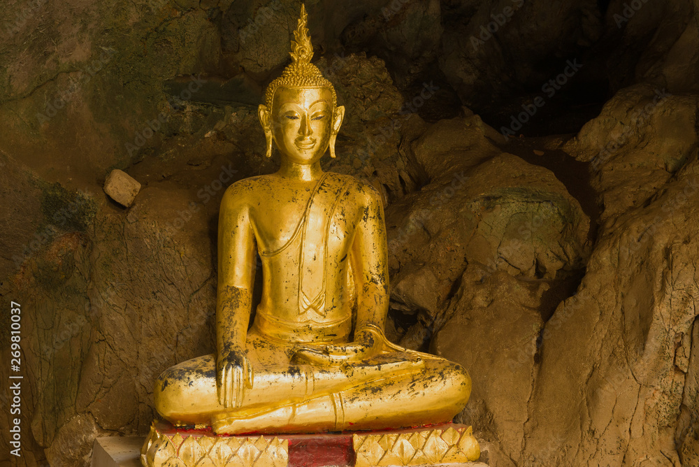 Ancient sculpture of a sitting Buddha close-up. Cave Temple Wat Tham Khao Luang. Phetchaburi, Thailand