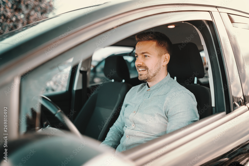 Smiling handsome caucasian man sitting in expensive car. Smiling handsome caucasian man sitting in expensive car.
