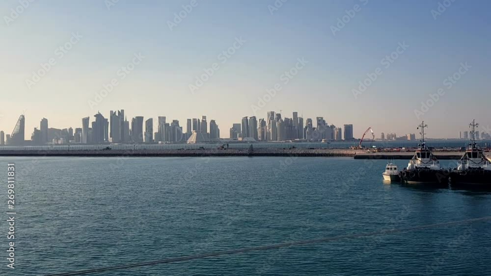 Sea port and view of the city with skyscrapers on the horizon. Sea port with moored ships. Skyscrapers on the background of blue sky. Sea port and view of the city with skyscrapers on the horizon. Sea port with moored ships. Skyscrapers on the background of blue sky.