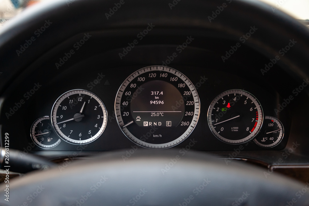 Car dashboard with speedometer, tachometer, clock, fuel tank gauge, oil temperature and display with on-board computer and black odometer with white arrows and divisions. Auto service industry.