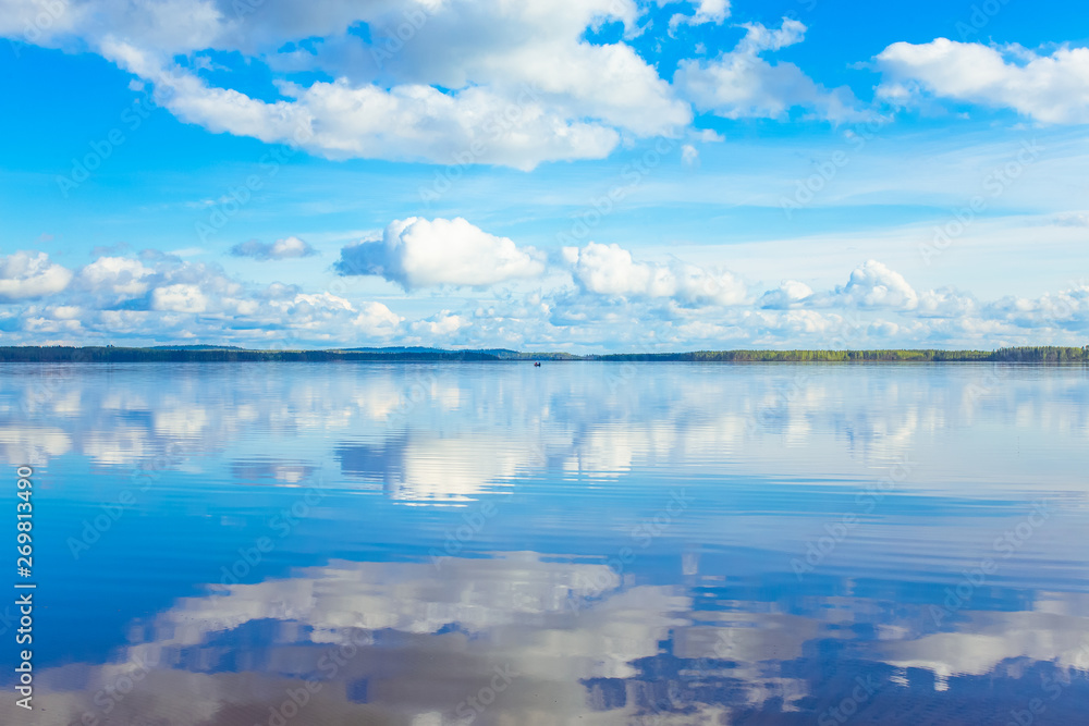 Summer lake landscape with fine reflections and dramatic sky. Sotkamo, Finland.
