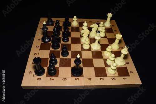 Wooden chess board under black pieces as a skill concept