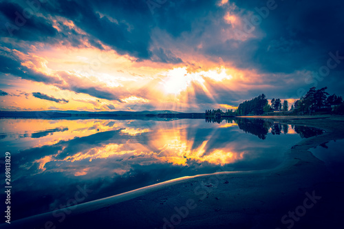 Summer lake landscape with fine reflections and dramatic sky. Sotkamo  Finland.