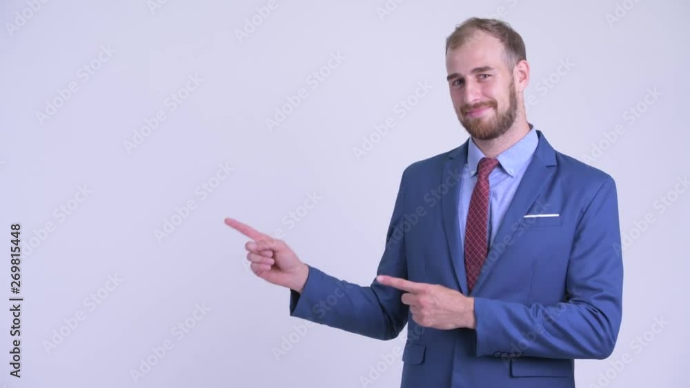 Happy bearded businessman pointing to the side Happy bearded businessman pointing to the side