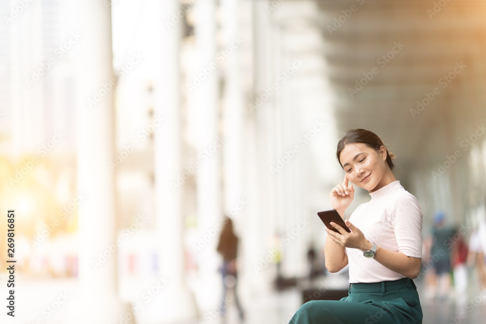 Fototapeta premium Happy woman using smart phone in the city