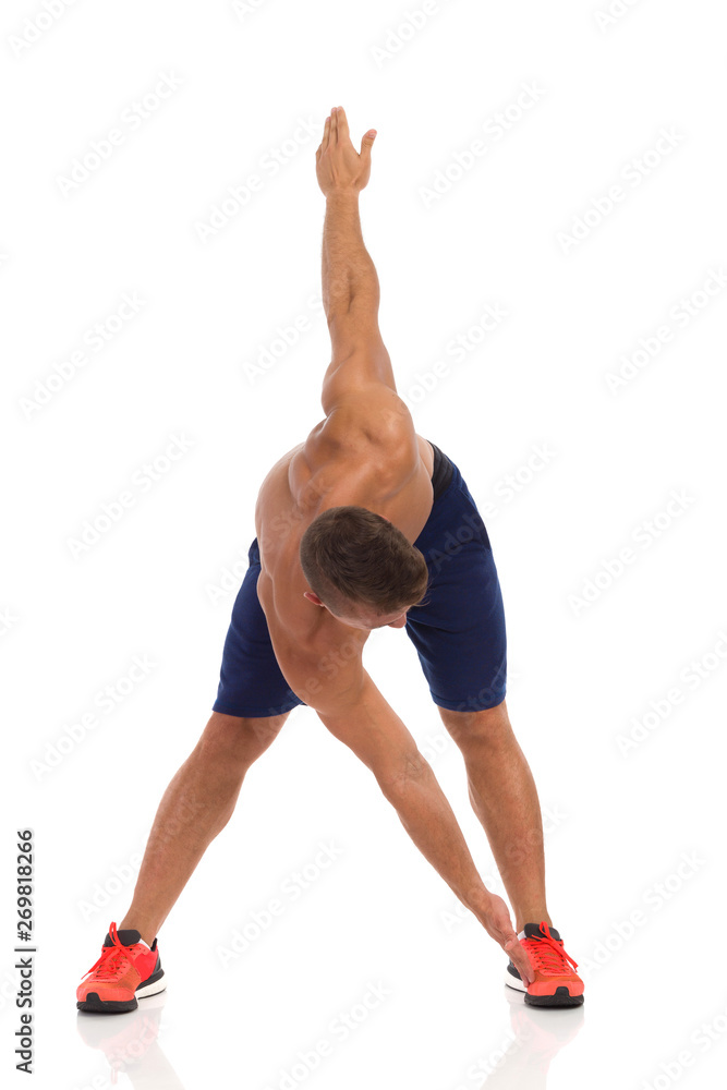Young Fit Man Makes A Slope To His Leg Young Fit Man Makes A Slope To His Leg