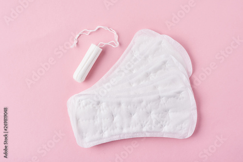 Sanitary pad and menstrual tampon on a pink background