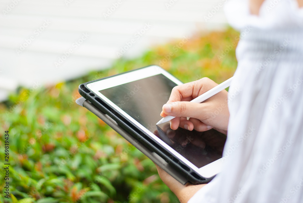 Women read or analyze reports on tablet computers. In the midst of nature